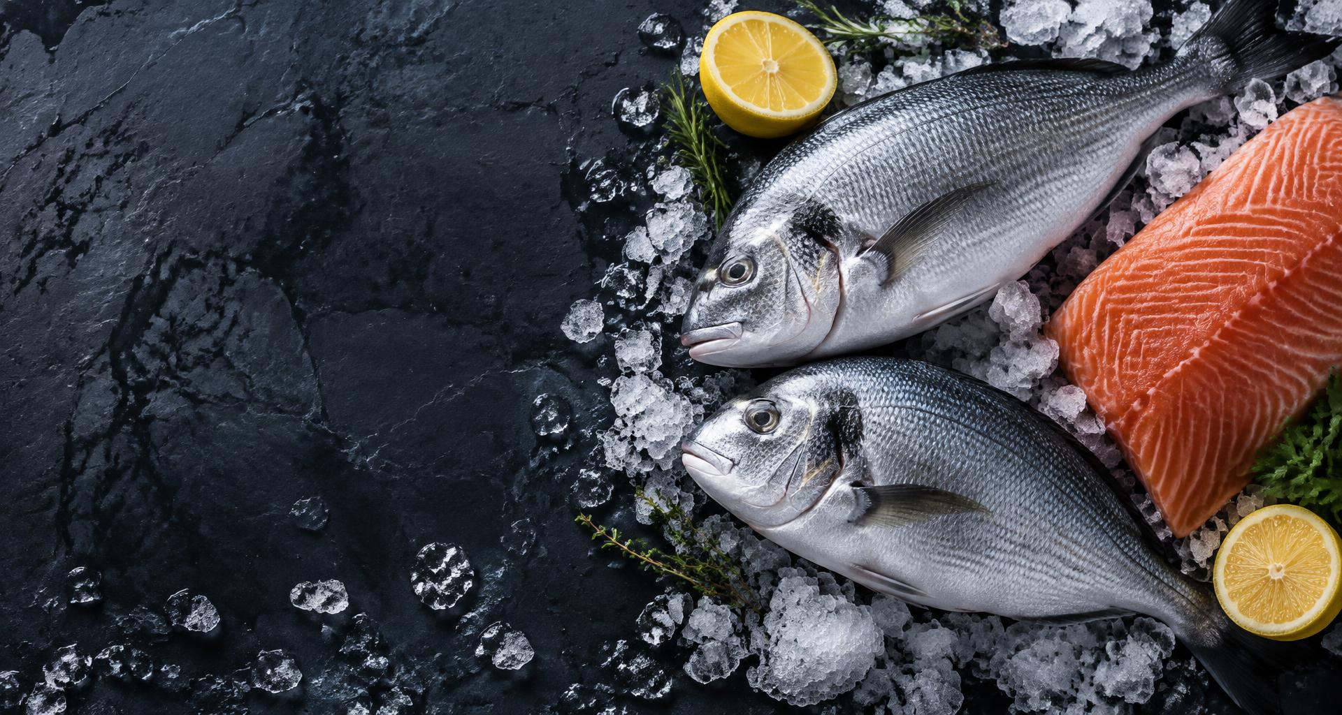 Pescados frescos y salmón sobre hielo, con limón y hierbas